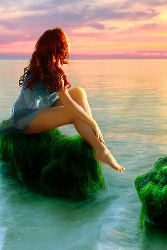 Русалка на зеленых камнях смотрит на закат