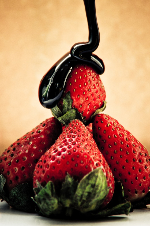 Шоколад льется на клубнику