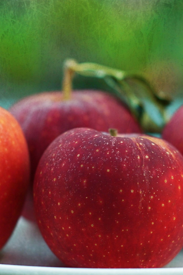 Четыре красных яблока на тарелке