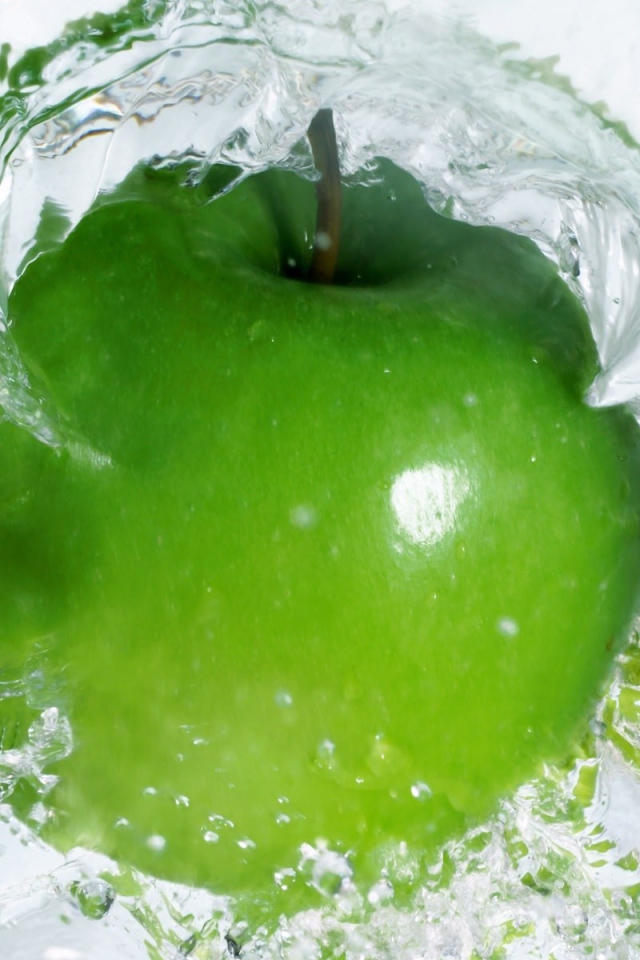 Зеленое яблоко в прозрачной воде