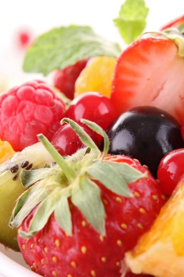 Кусочки спелых фруктов и ягоды на тарелке