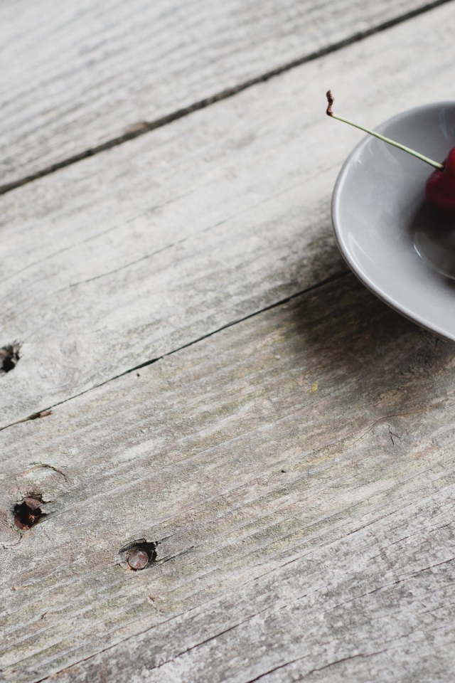 Две красных вишни в керамической чашке