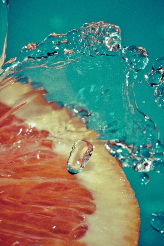 Вода льется на срез грейпфрута