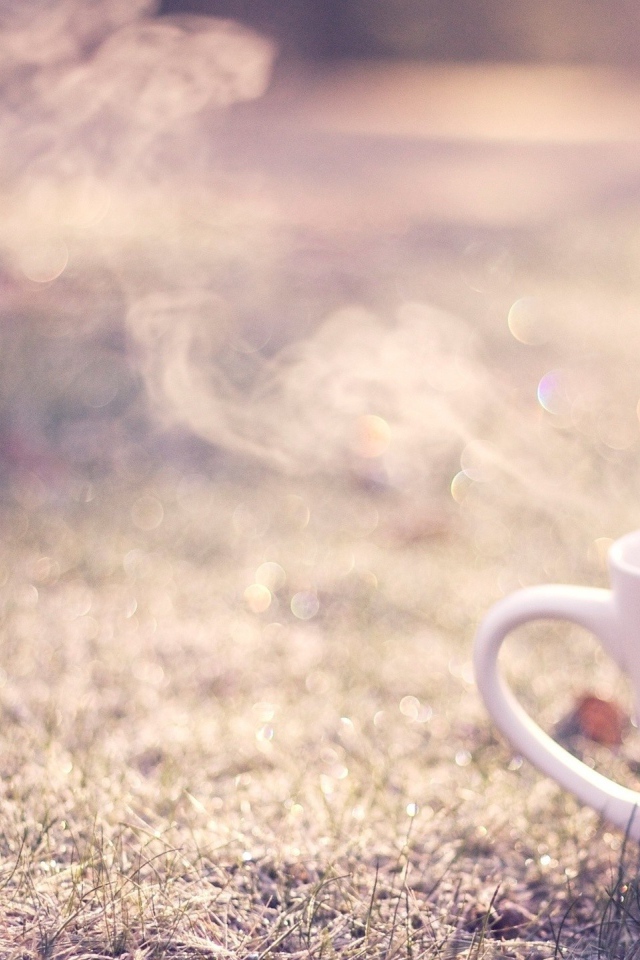 Дымящаяся чашка на траве