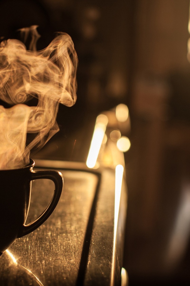 Пар из чашки кофе на закате