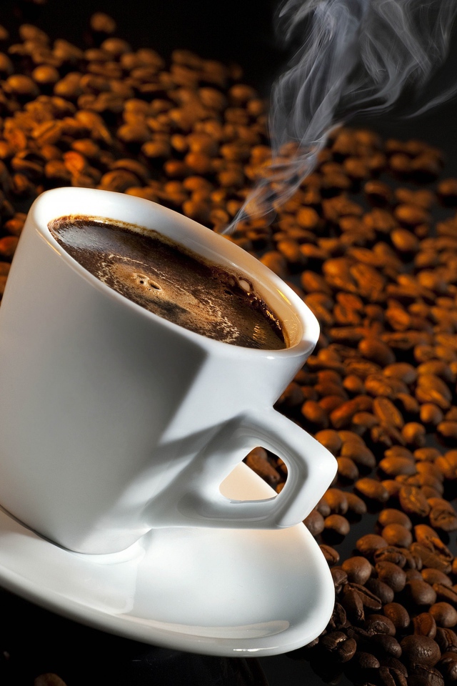 Белая чашка с кофе на зернах