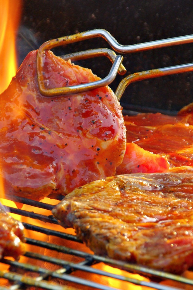 Стейк жарится на огне барбекю