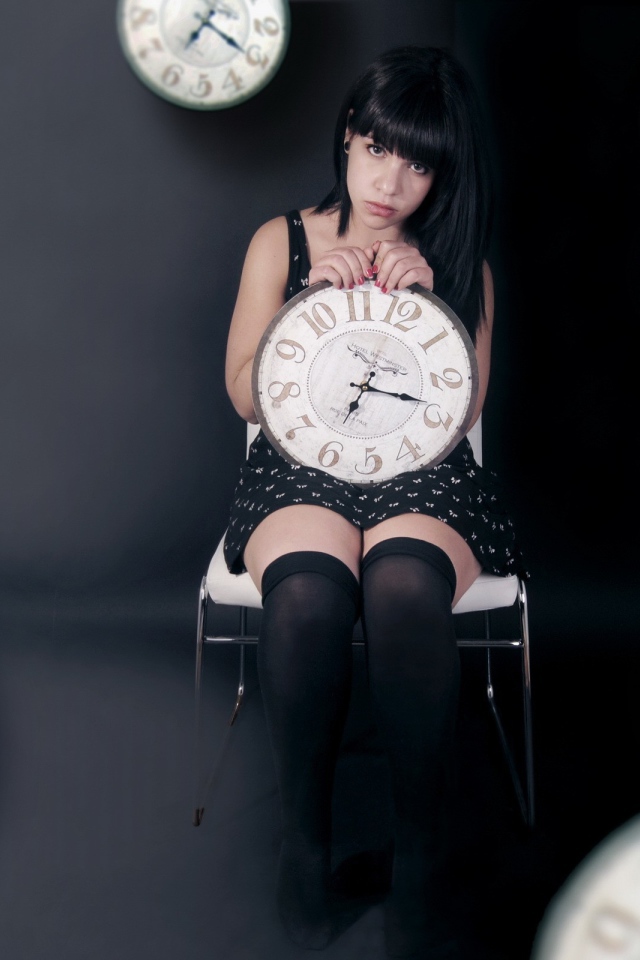 Девушка держит в руках часы