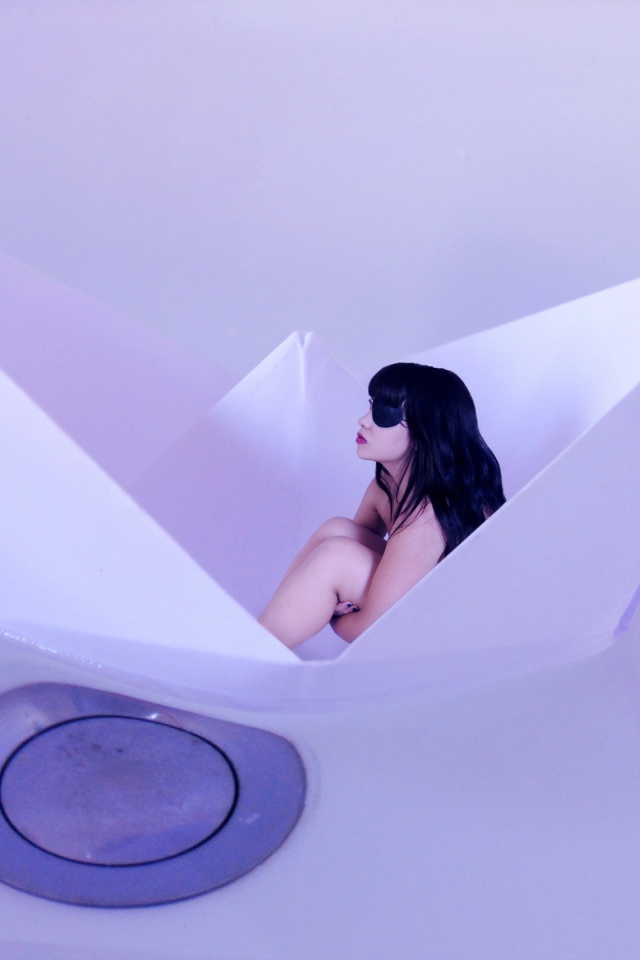 Девушка сидит в бумажном кораблике