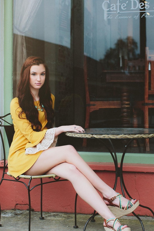 Девушка сидит за столиком уличного кафе