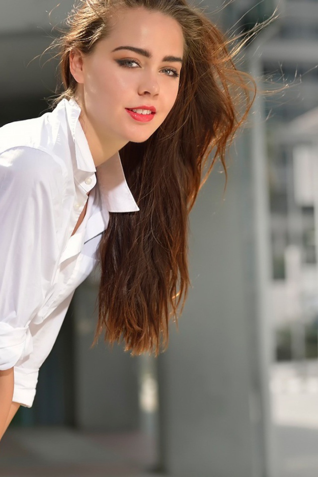 Девушка стоит у вентилятора