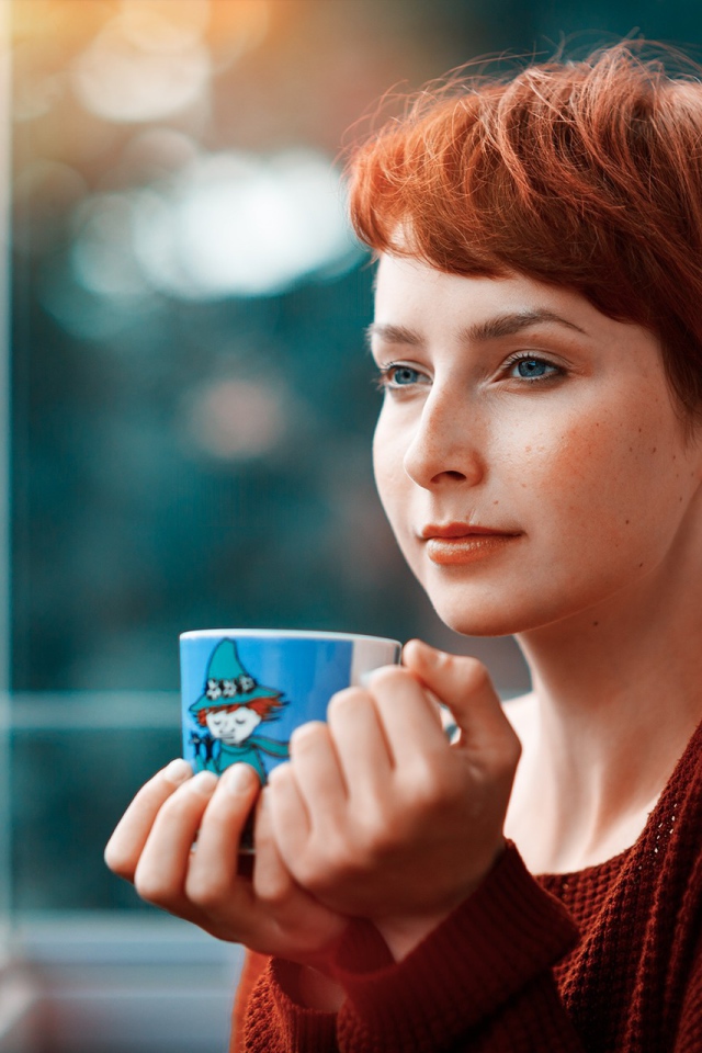 Девушка с короткими волосами пьет кофе