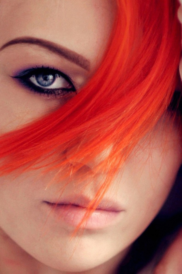 Прядь оранжевых волос на лице у девушки