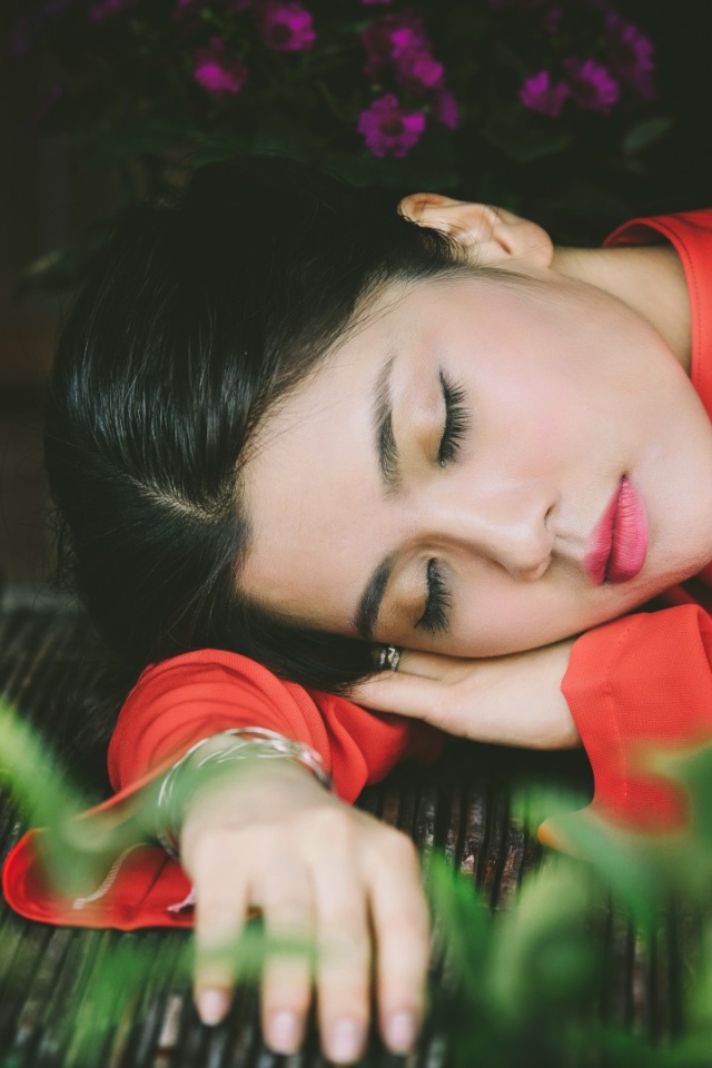 Азиатка спит положив голову на руки