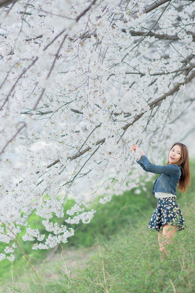 Азиатская девушка радуется весенним цветам