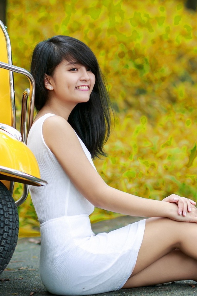 Азиатская девушка у желтого мотороллера