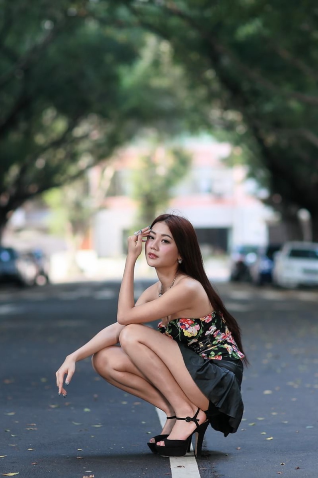 Азиатская девушка сидит на корточках