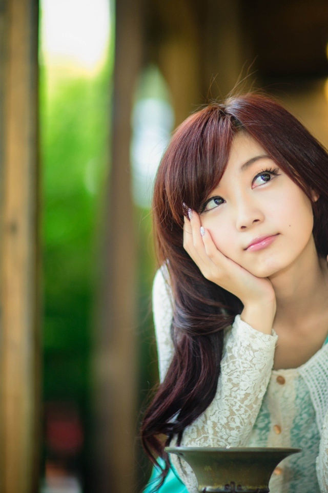 Азиатская девушка задумчиво смотрит вверх