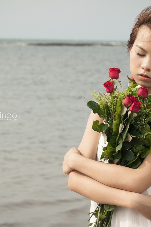 Азиатка держит в руках букет роз