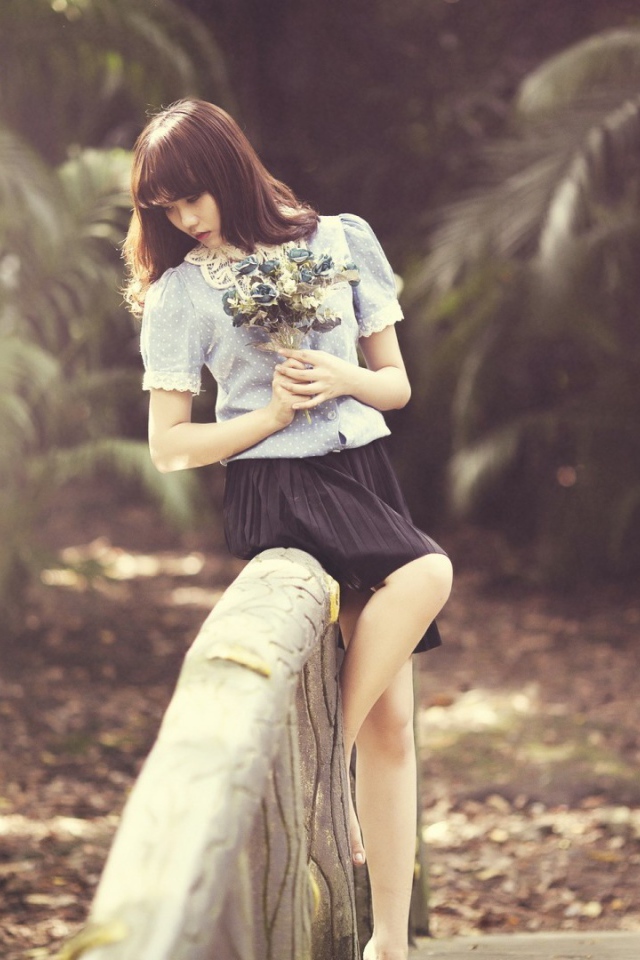 Азиатка с букетом на поручне моста