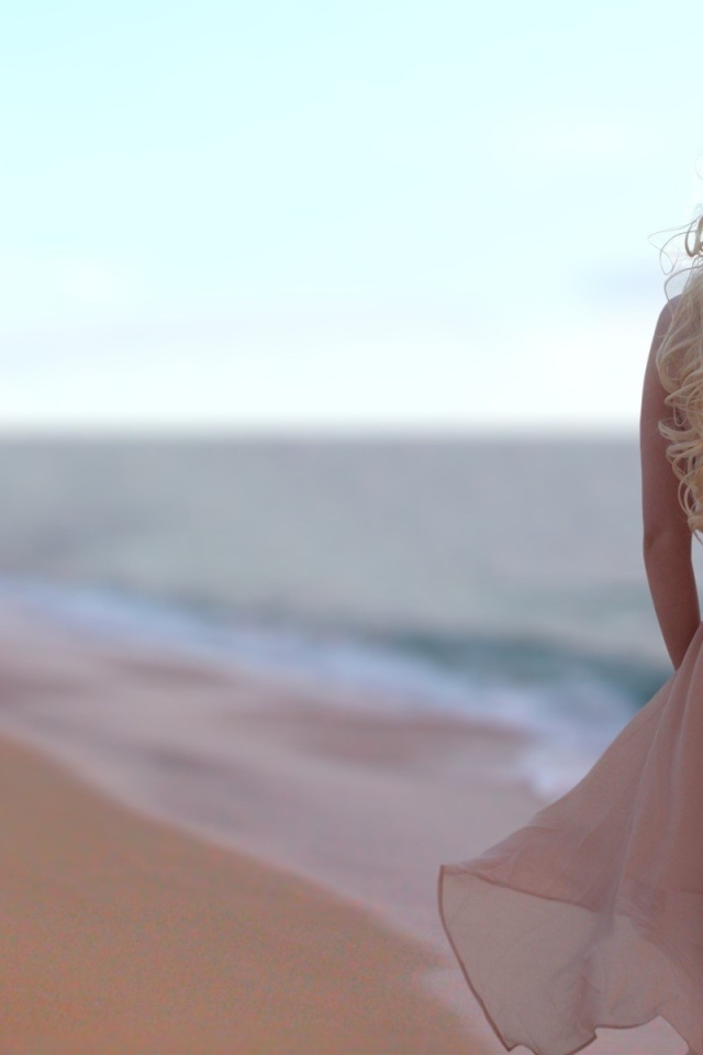 Блондинка в легком платье на пляже