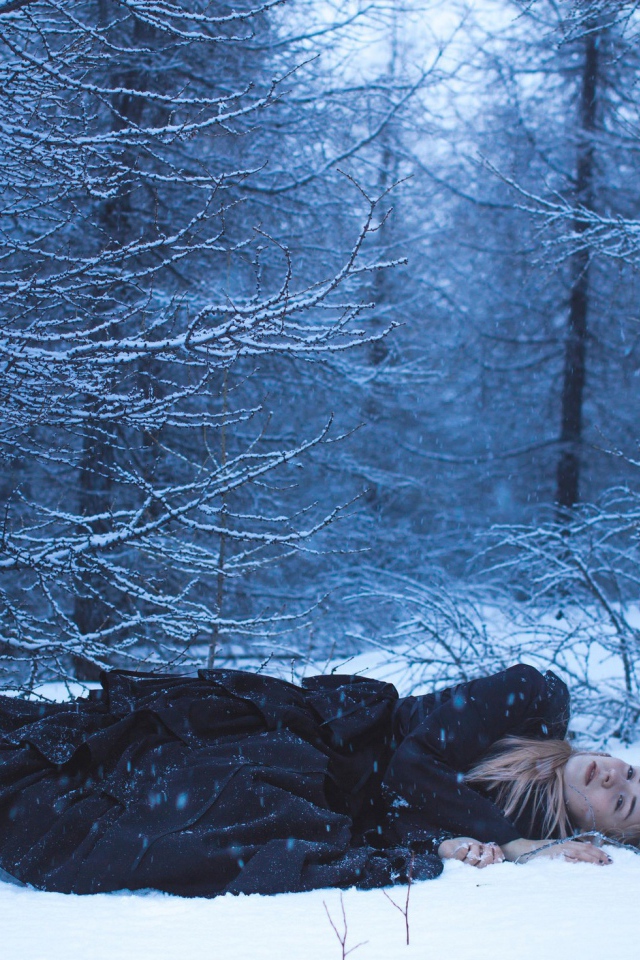 Блондинка лежит на снегу в лесу