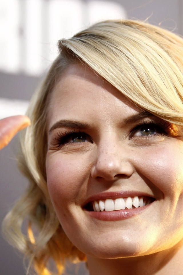 Блондинка улыбается и машет