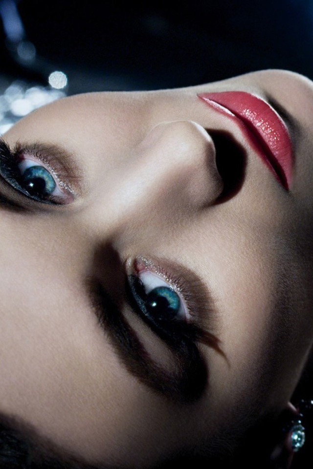 Голубоглазая брюнетка лежит в черном платье