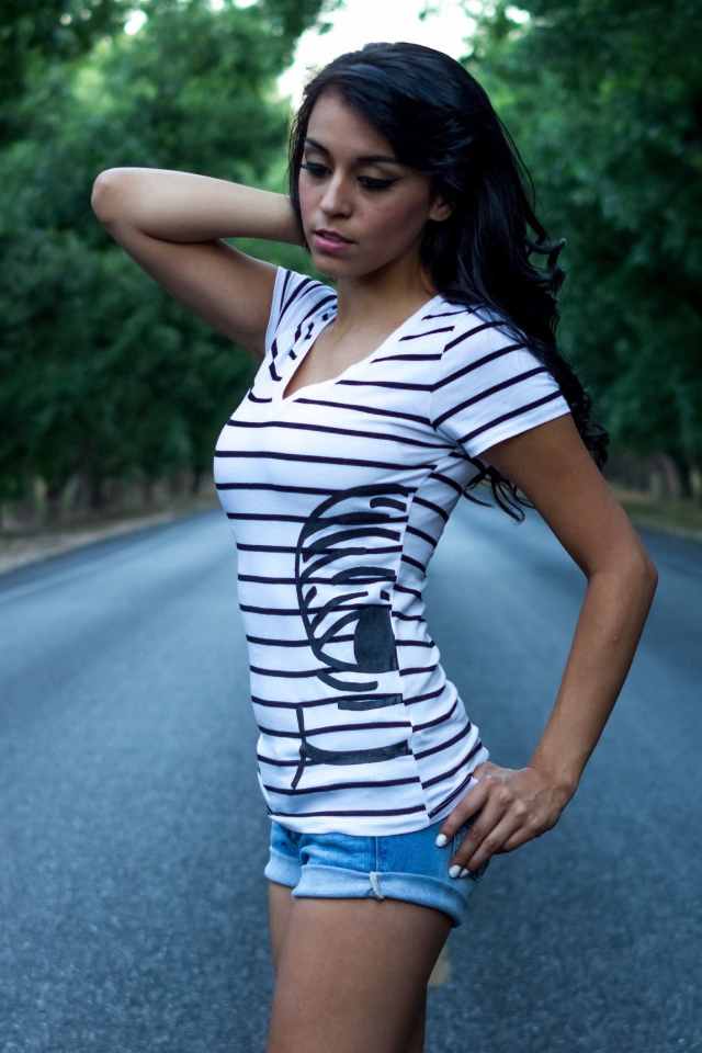 Брюнетка в джинсовых шортах среди дороги
