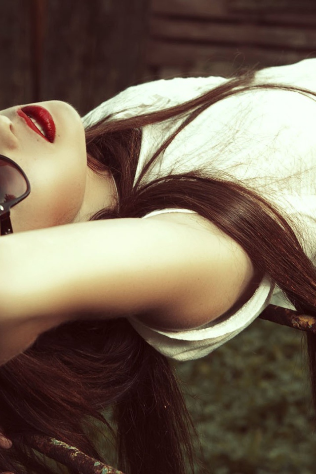 Брюнетка в темных очках смотрит в небо