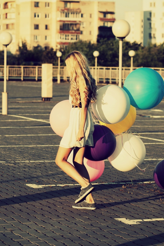 Связка воздушных шаров в руках юной девушки