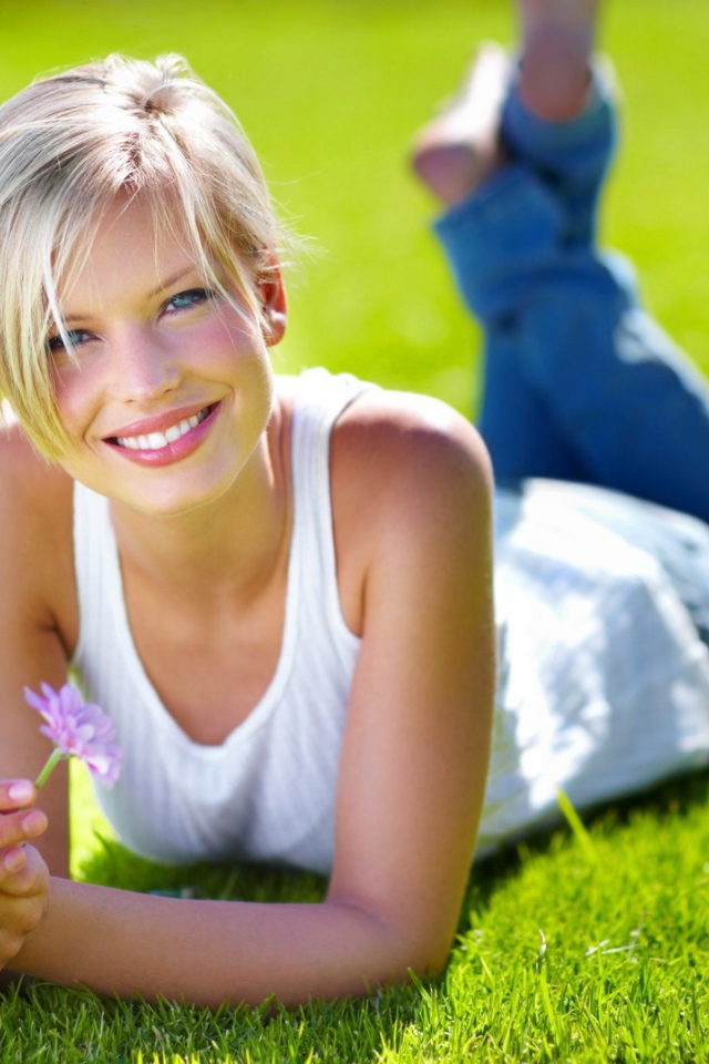 Милая блондинка на нежно зеленом газоне