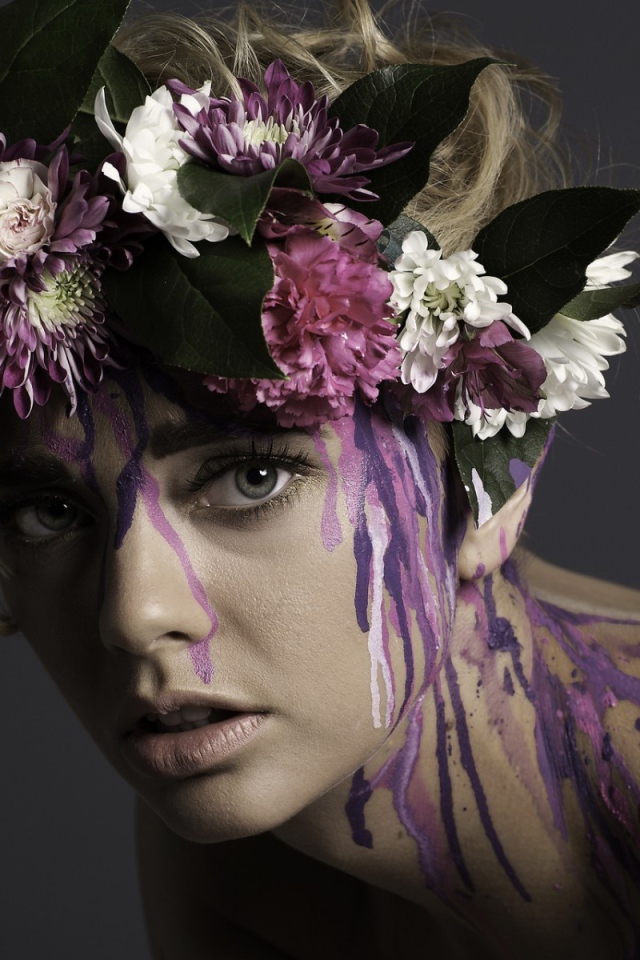 Цветочный венок на голове девушки и брызги краски по телу