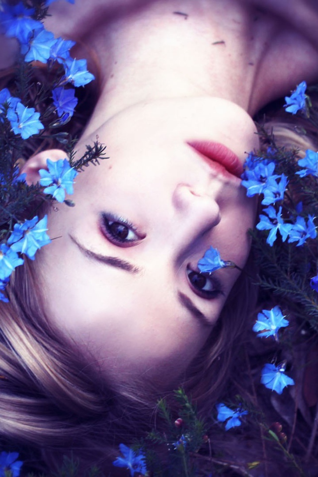 Девушка среди маленьких голубых цветов