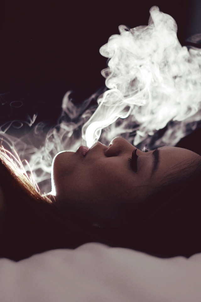 Девушка выпускает дым изо рта