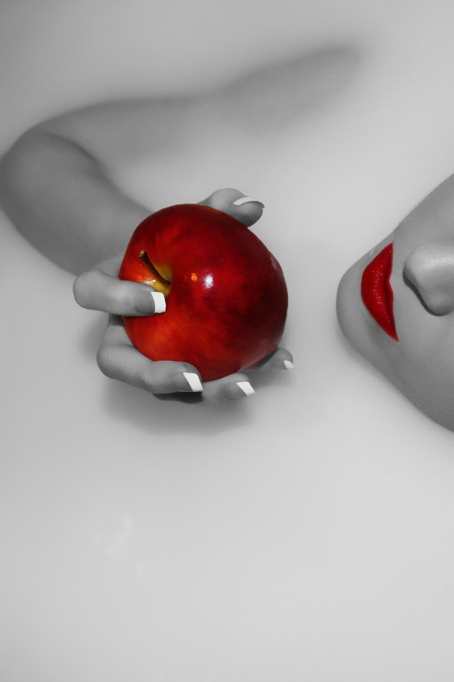 Девушка ест яблоко лежа в ванной