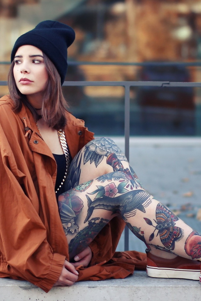 Девушка в шапке с тату на ногах