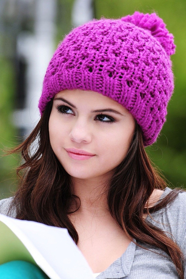 Девушка в сиреневой шапке читает книгу