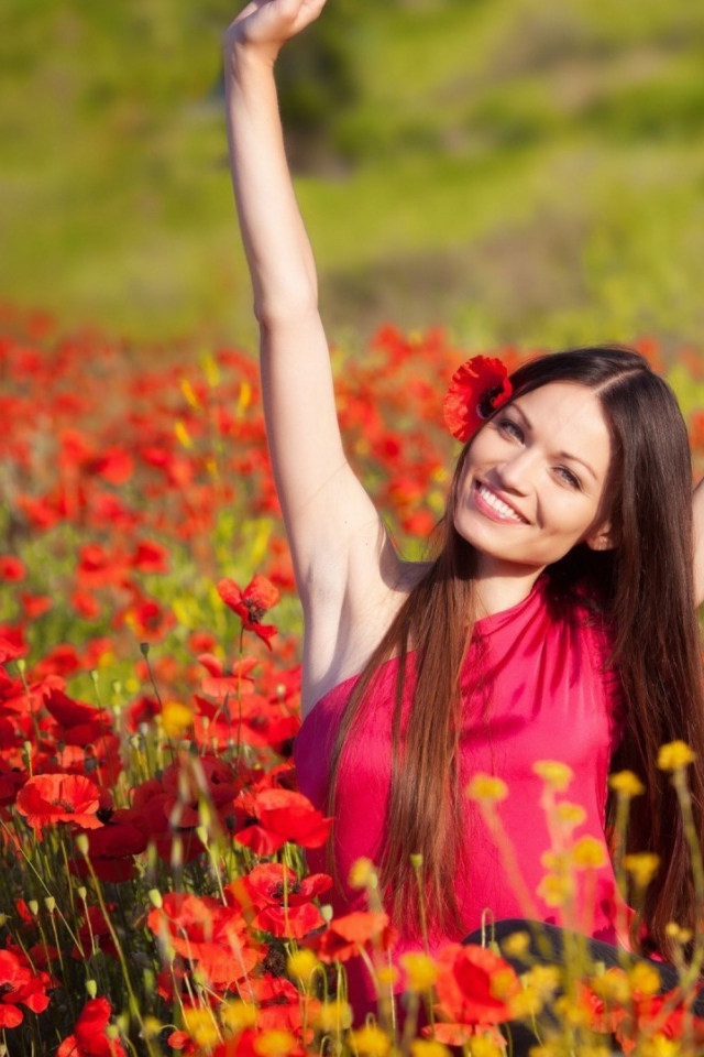 Girl in a red dress on a field of poppies