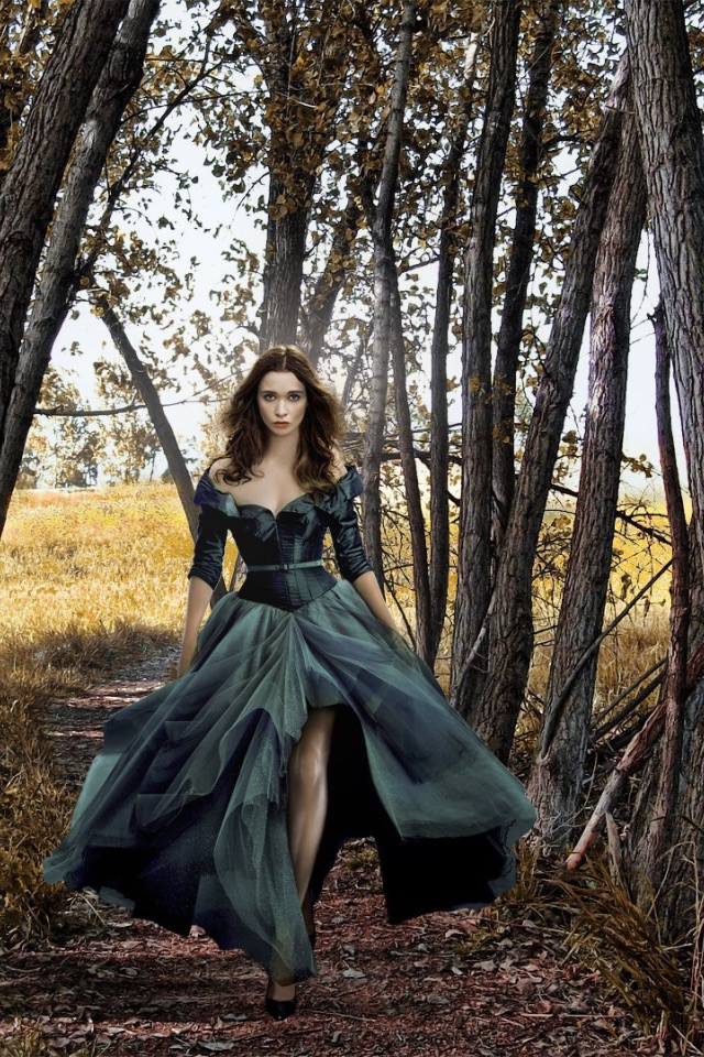 Девушка в черном платье среди деревьев