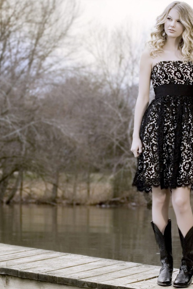 Девушка в черном платье и кожаных сапогах