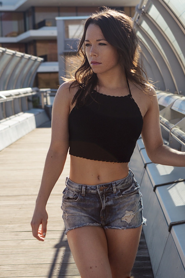 Девушка в джинсовых шортах на мосту