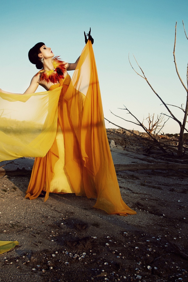 Девушка в оранжевом позирует в пустыне