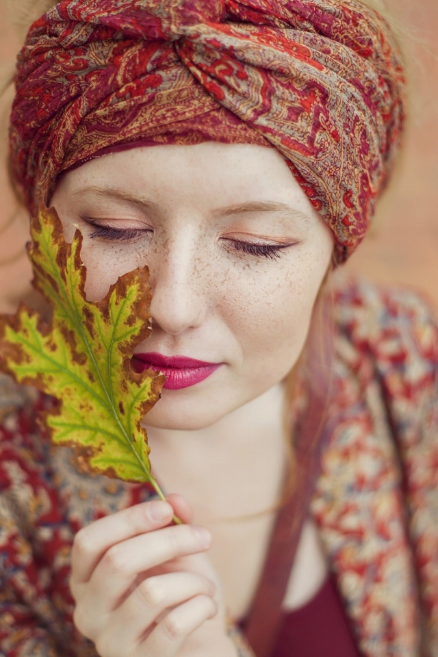 Девушка в традиционном наряде держит в руке лист