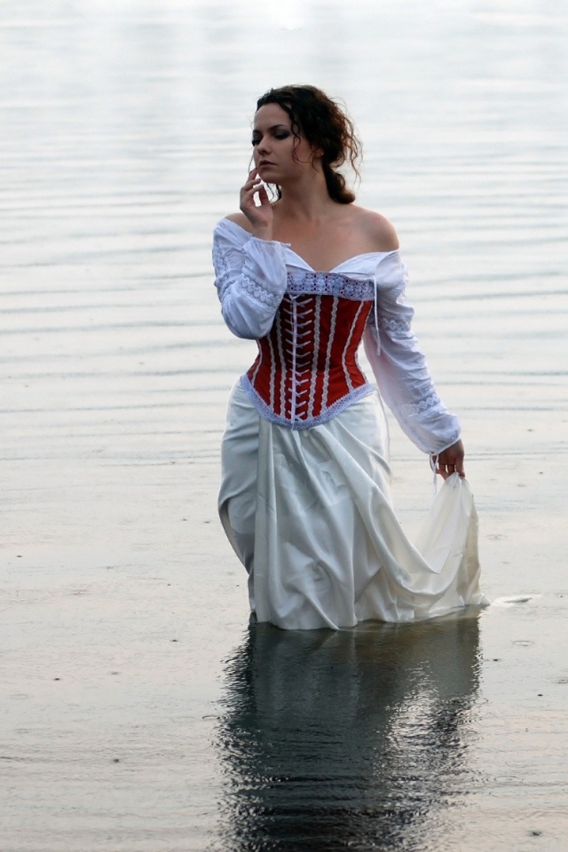 Девушка в белом платье стоит в воде