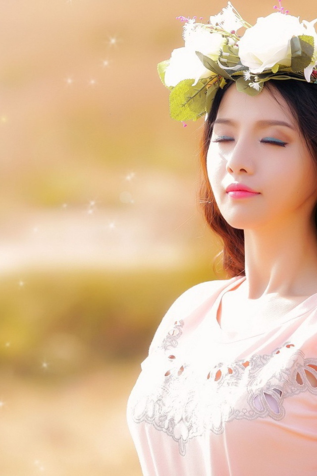 Девушка в белом венке прикрыла глаза