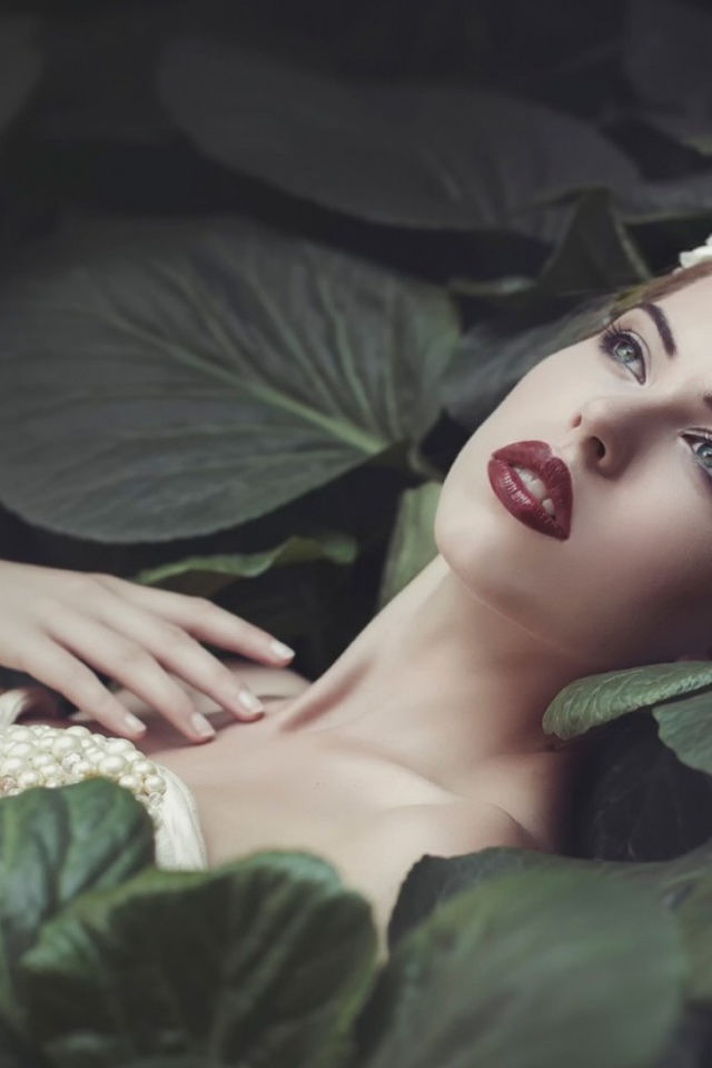 Девушка лежит в больших листьях