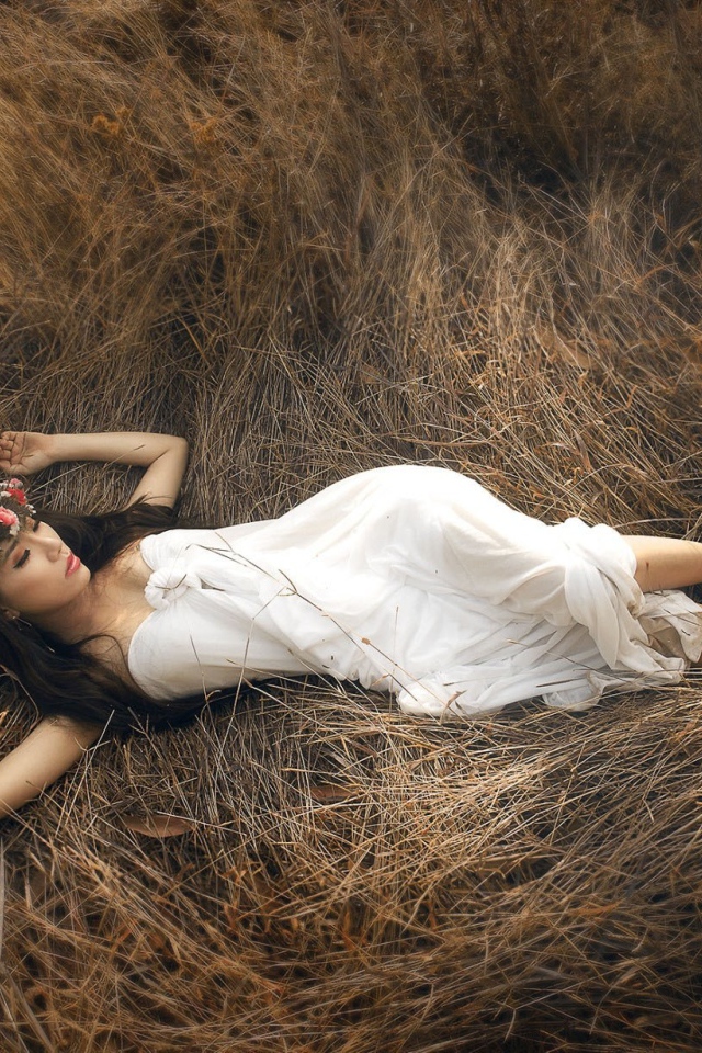 Девушка лежит на сухой траве