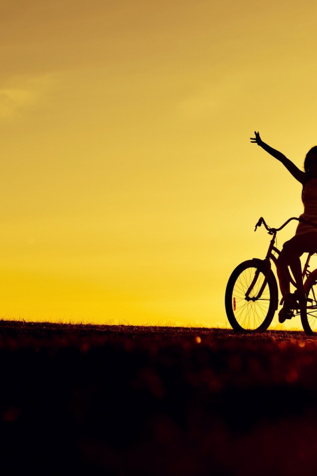 Девушка на велосипеде на фоне заката