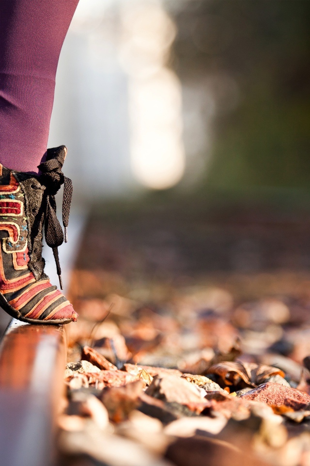 Девушка на носочках на рельсе